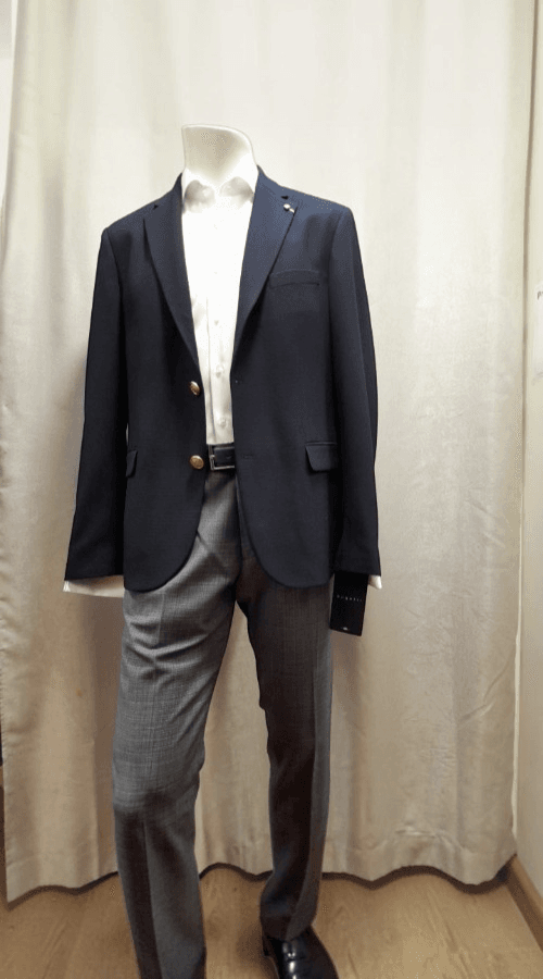 Tenue homme avec blazer bleu marine, chemise blanche et pantalon gris disponible chez Morny Habillement à Deauville